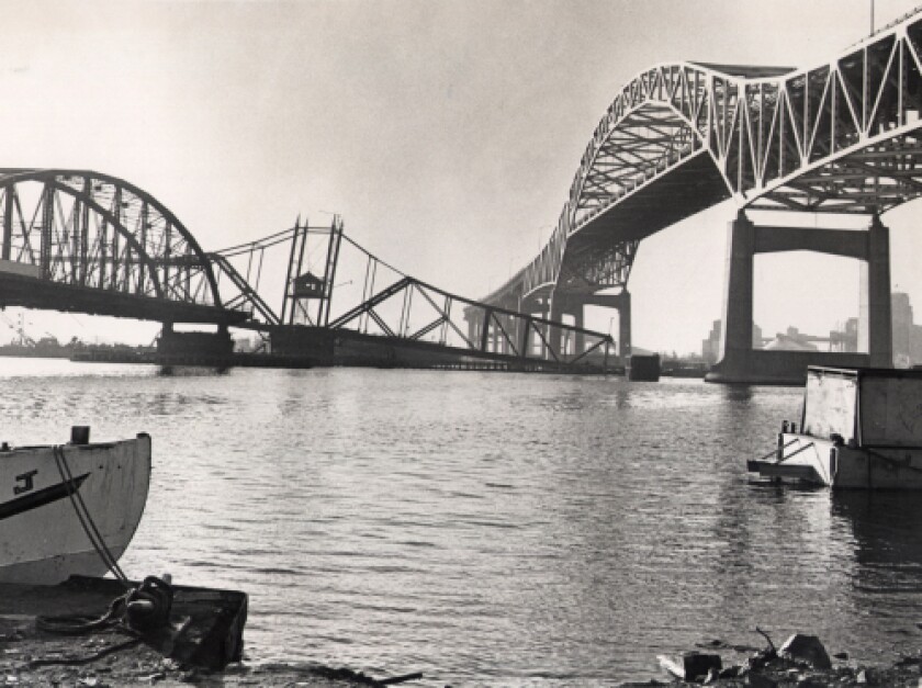 Center span of Interstate Bridge tilts below its replacement, the Blatnik Bridge, as old span is removed