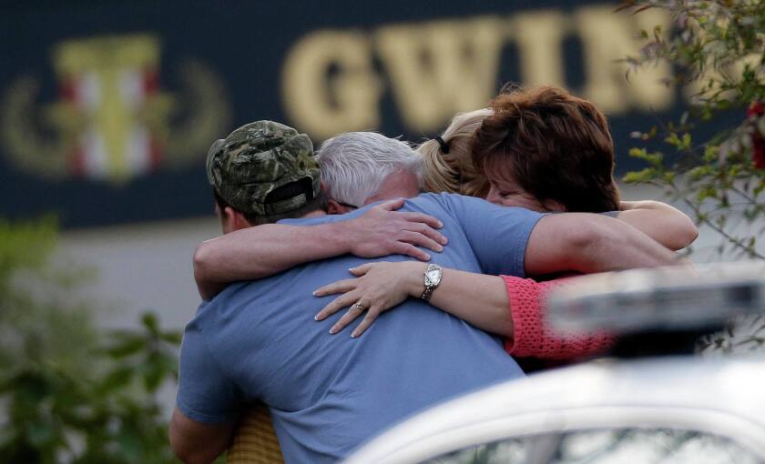 A group of people huddle together after an explosion and gunshots were heard