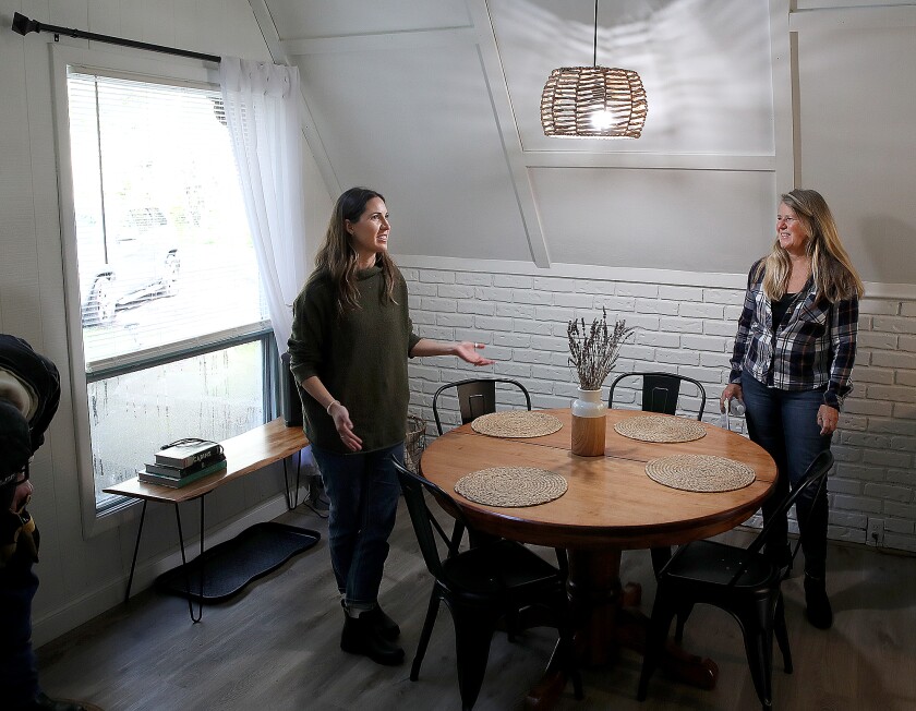 Rachel Hartshorn, left, and Diana Cole talk about all the fixes they made in the A-frame they bought in Herbster