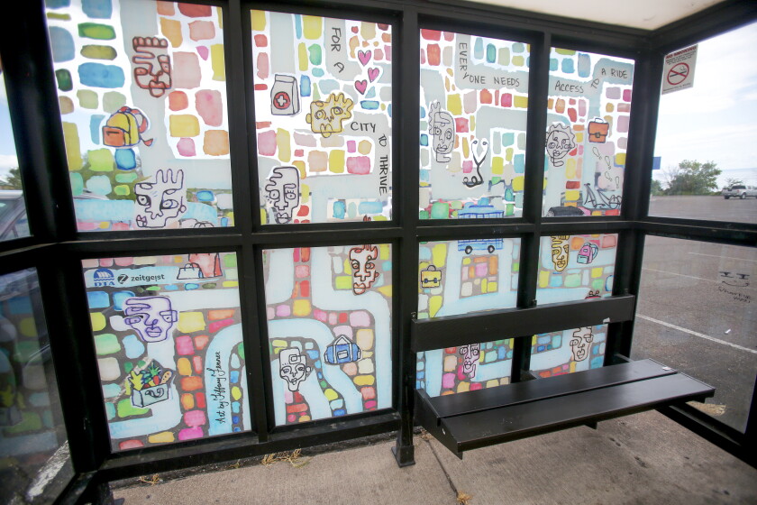 A bus shelter with a mural decorating the windows