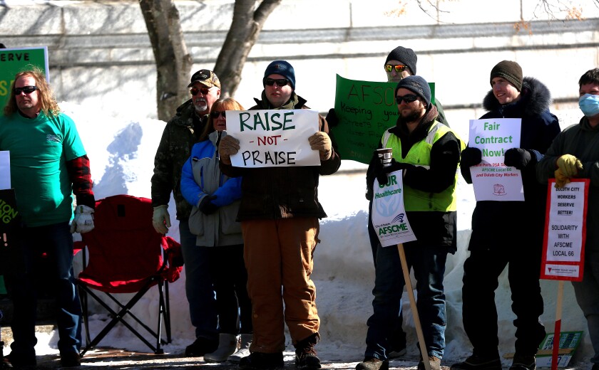 man holding a placard at a rally