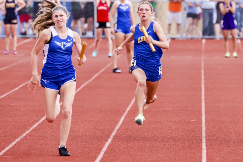 Athletes compete in track and field events at outdoor stadium