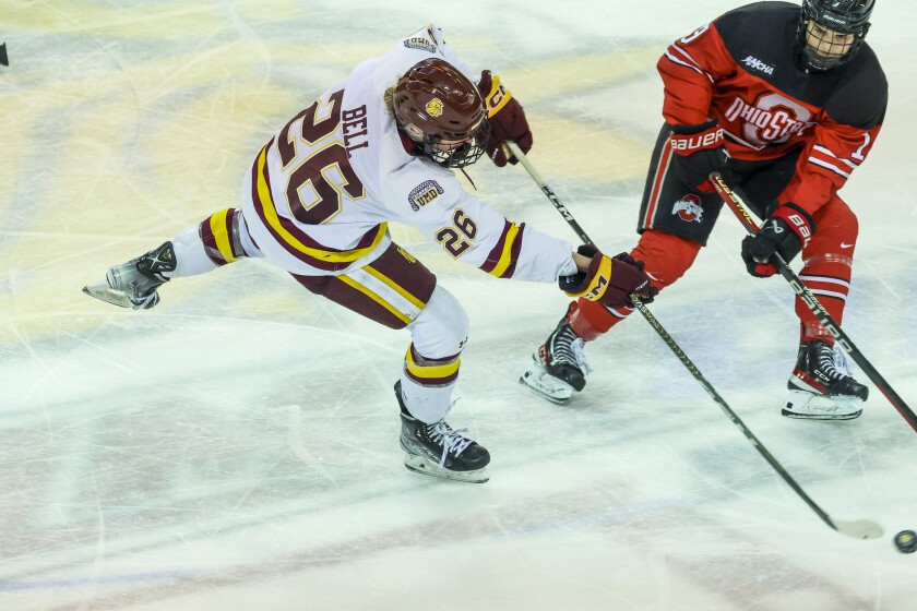 women hockey players compete during game