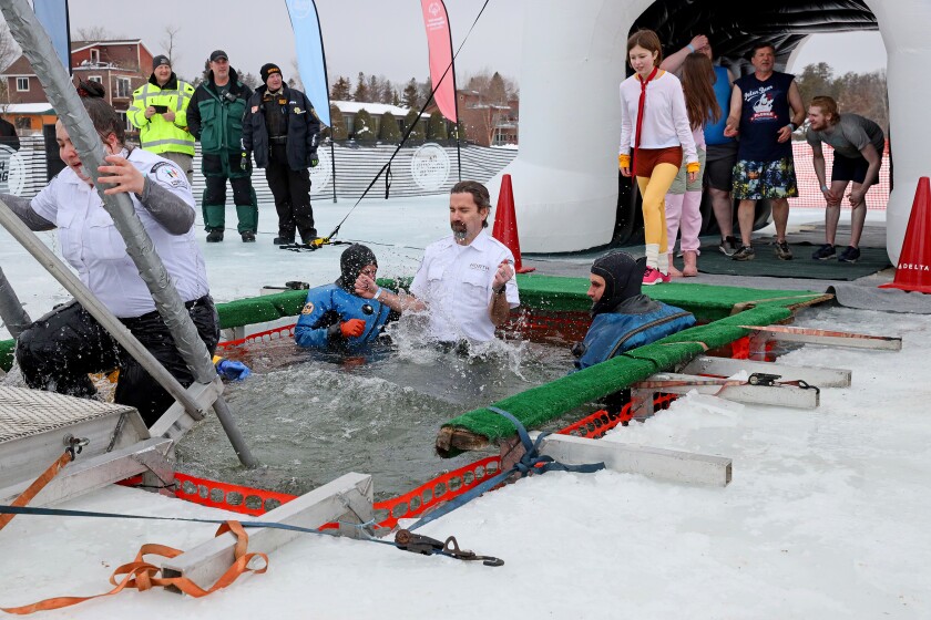 People jump into the water during the Polar Plunge event on Pelican Lake.