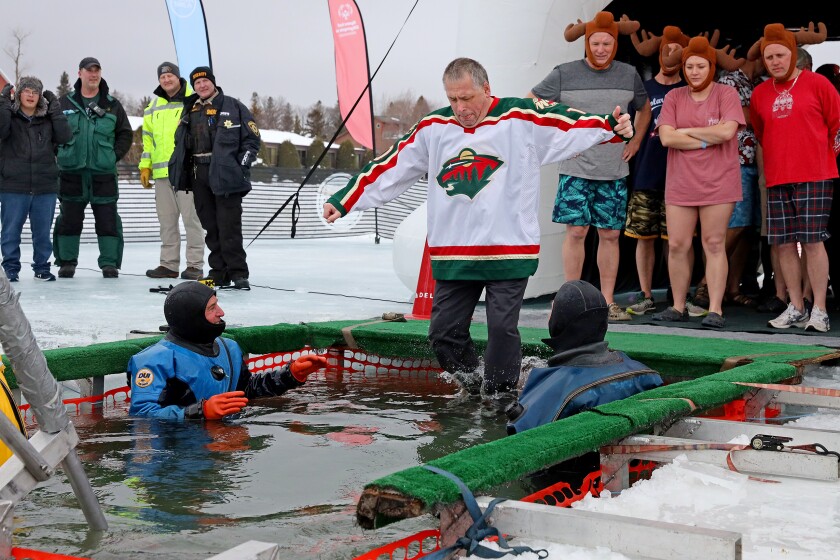 People jump into the water during the Polar Plunge event on Pelican Lake.