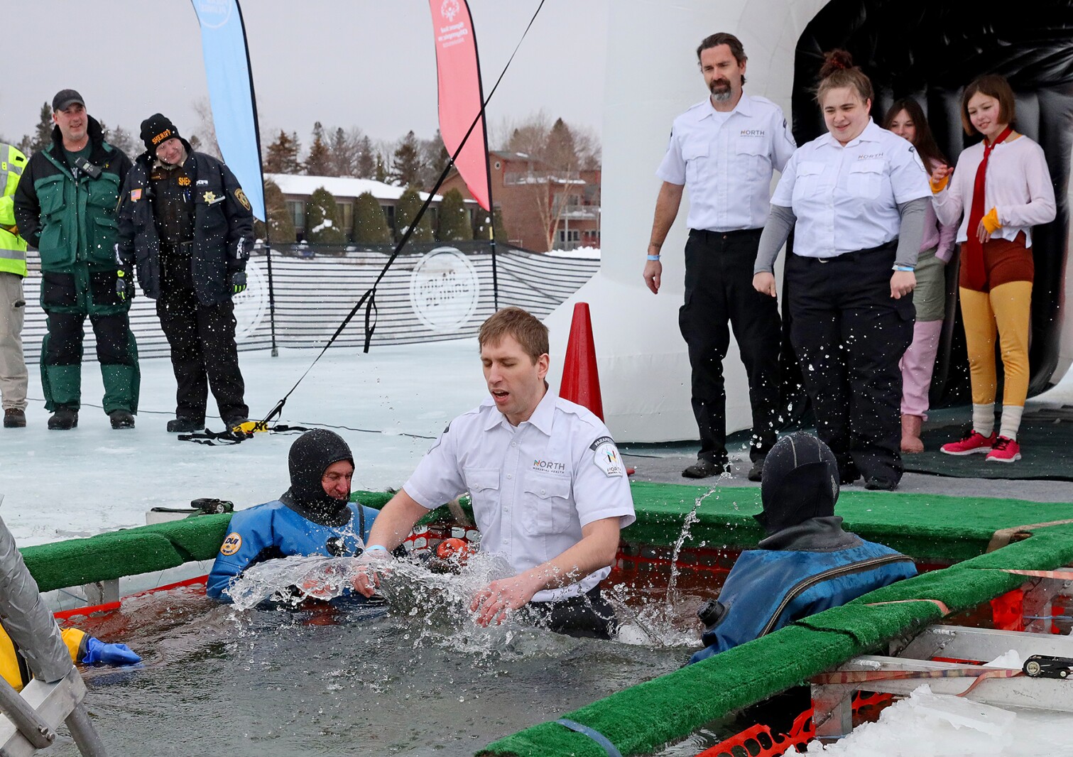 People jump into the water during the Polar Plunge event on Pelican Lake.