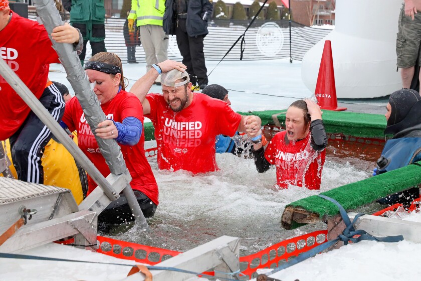 People jump into the water during the Polar Plunge event on Pelican Lake.