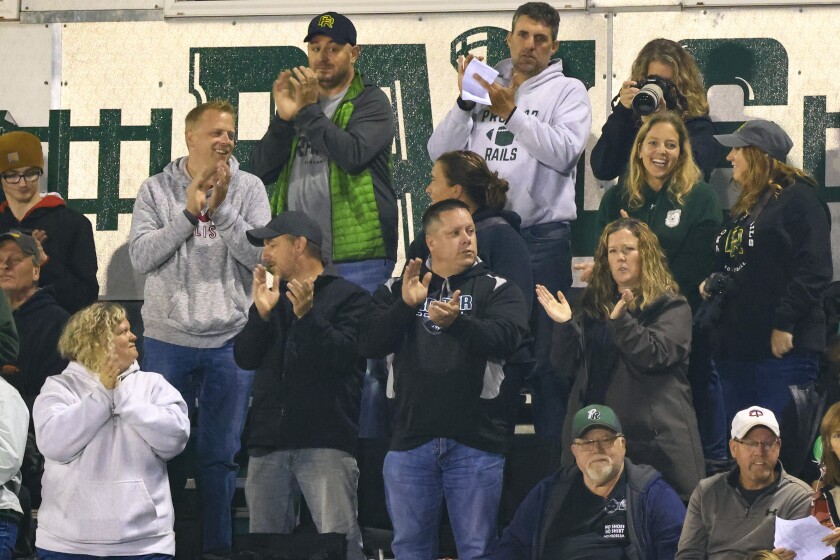 Football players and fans at outdoor high school game