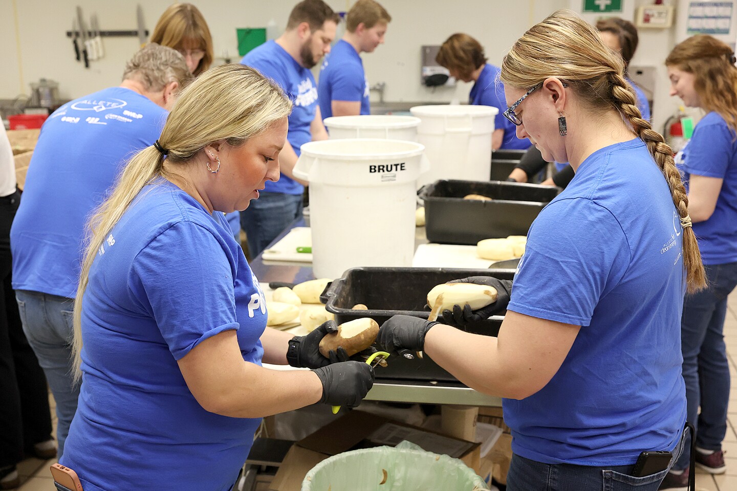 Women peel potatoes.