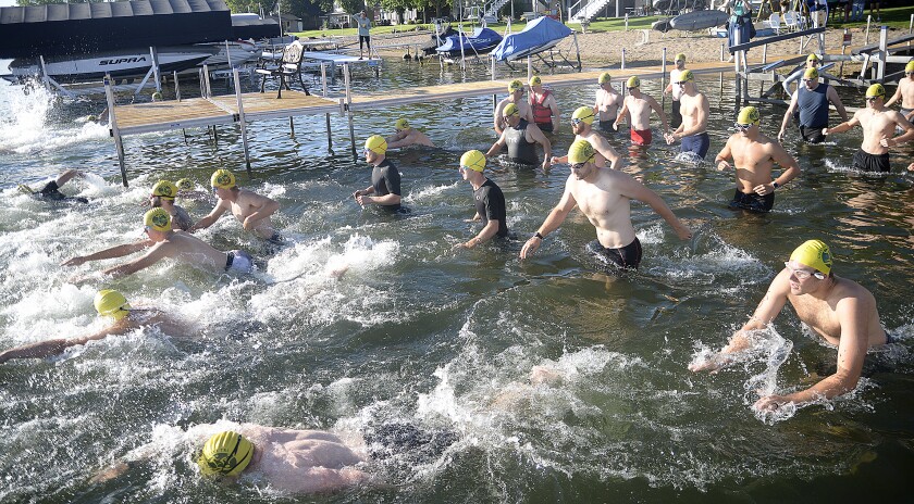A group of male athletes begin their quarter-mile swim at the start of the Green Lake Triathlon on Sunday, Aug. 14, 2022 at Spicer.