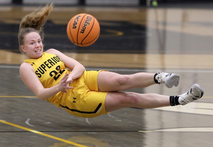 UW-Superior’s Elise Besonen (22) falls to the court after saving the ball from going over half court