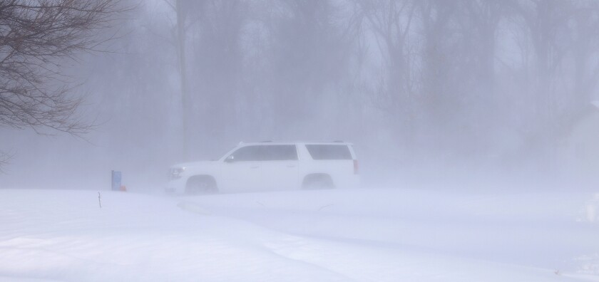 A white Chevrolet Suburban is stuck in a snow drift between farm groves on Nobles County 12, west of Worthington, Friday afternoon, Dec. 23, 2022.