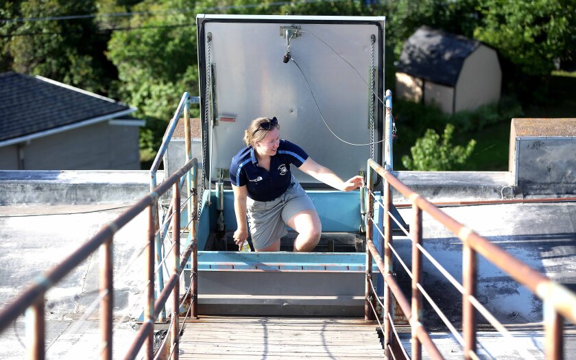 Duluth Huskies staff member climbs to the top of Wade Stadium
