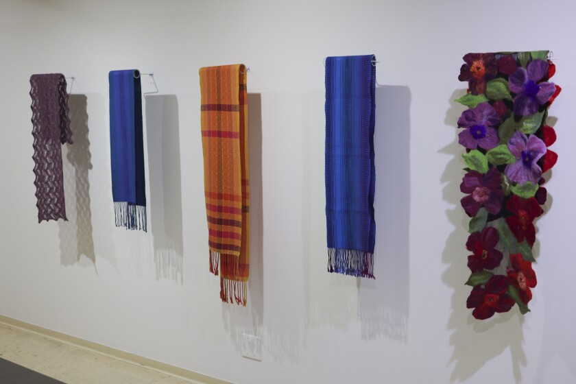 women looking at fiber art in gallery