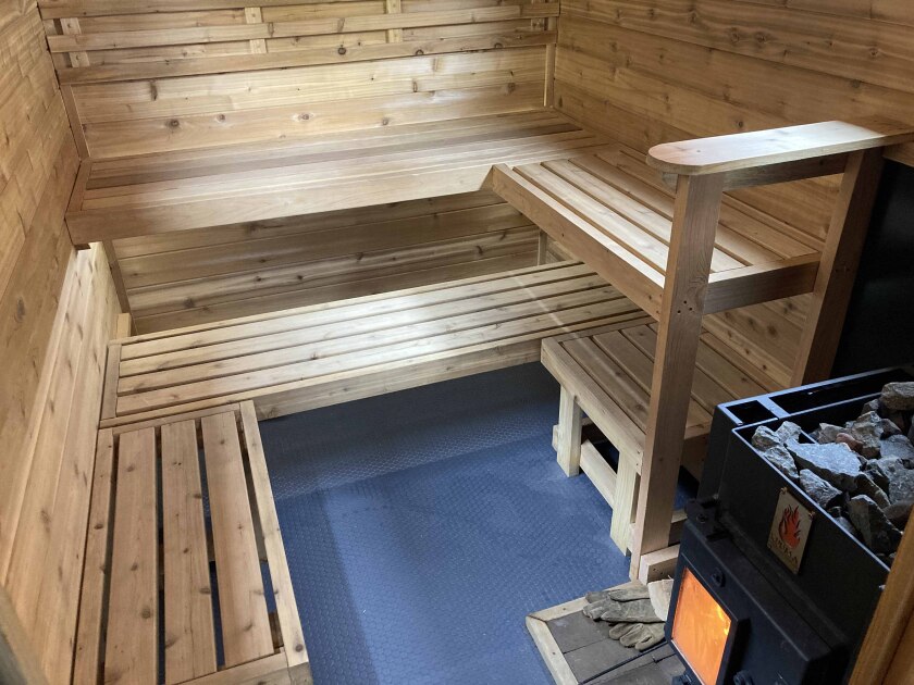 Benches and a stove inside of a mobile sauna