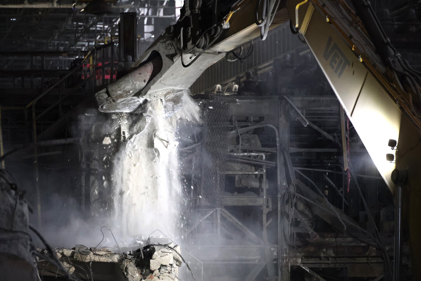 Crane tears down structures inside retired pellet plant