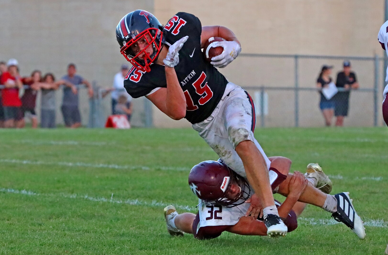 A defender shoestring tackles a runner with the ball.