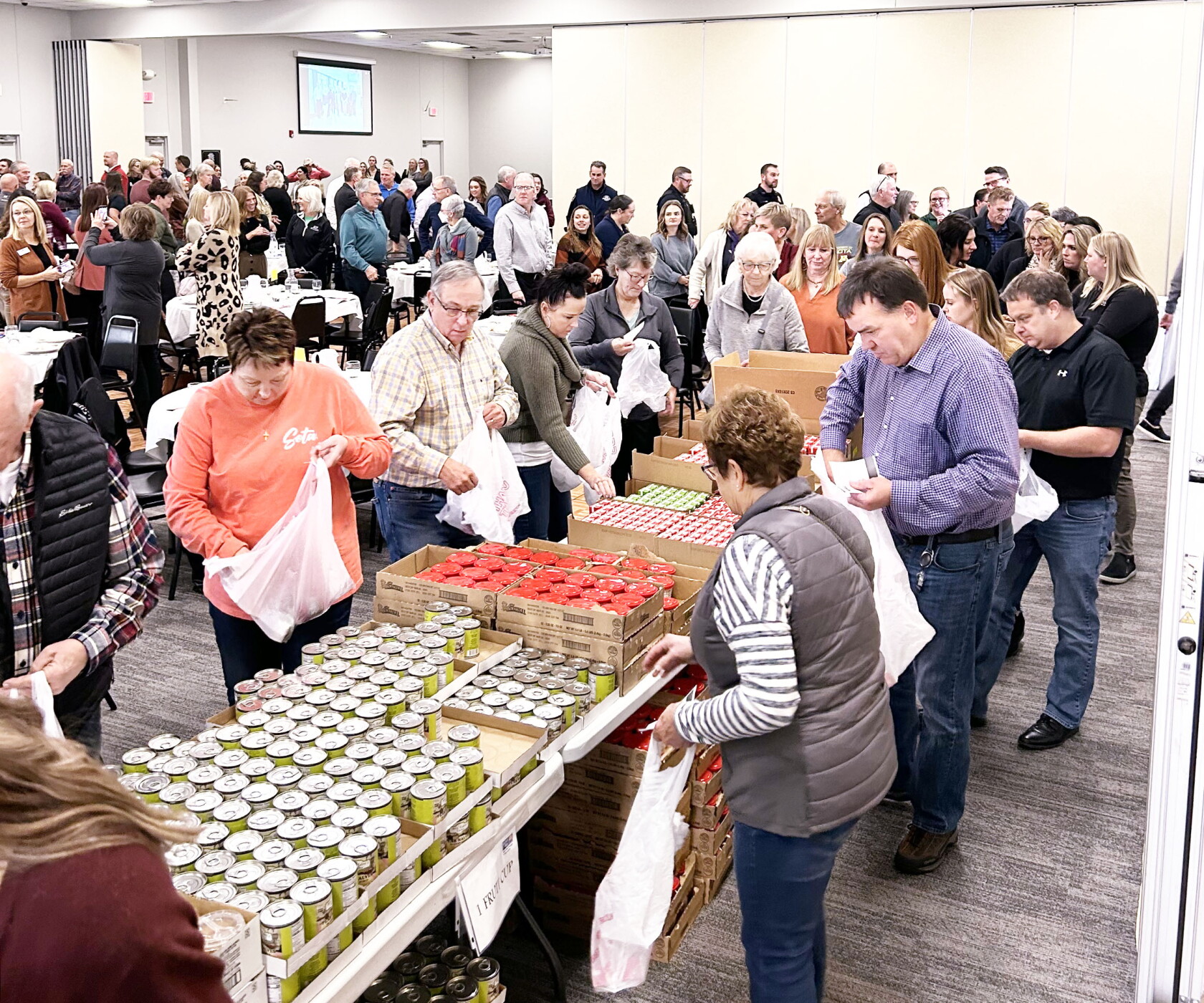 United Way luncheon attendees pack food bags for Backpack Attack ...