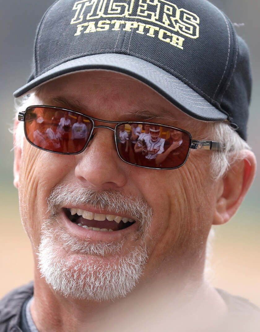 The Northwestern softball team is reflected in head coach Scott Janigo’s glasses as he talks to his team