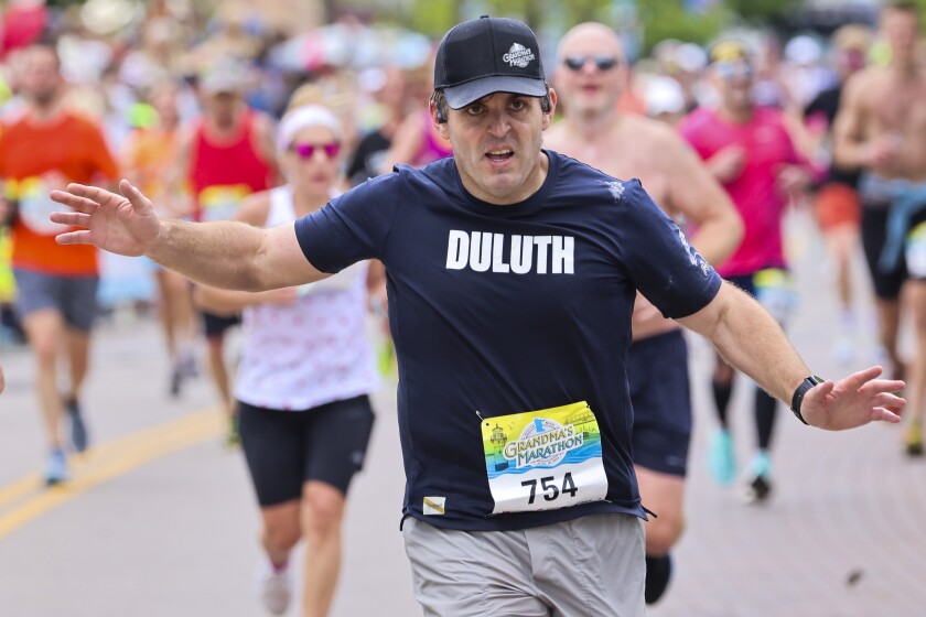 Athletes running and celebrating at the finish line area of Grandma's Marathon