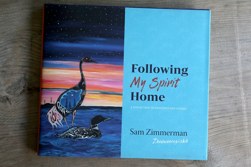 copy of Sam Zimmerman’s book “Following My Spirit Home” rests on a bench in his studio
