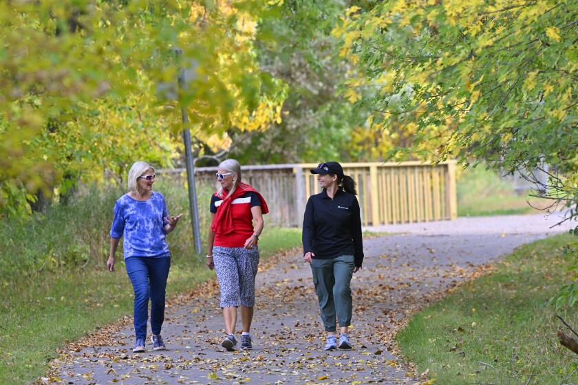 Three women walking in fall colors.