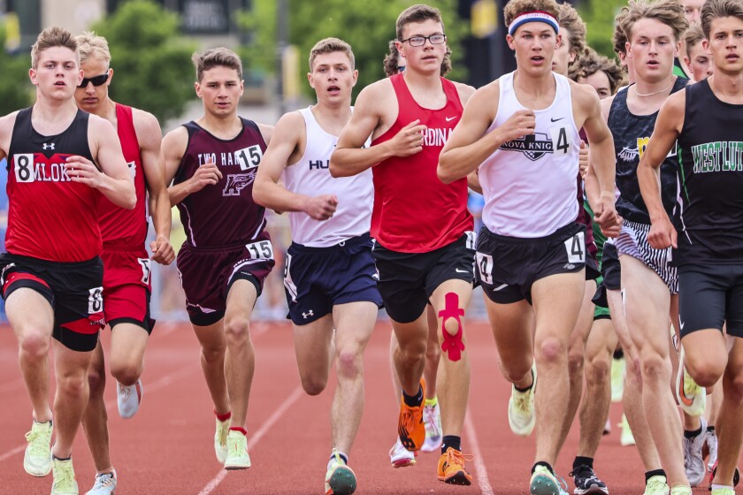 Athletes compete in track and field events at outdoor stadium