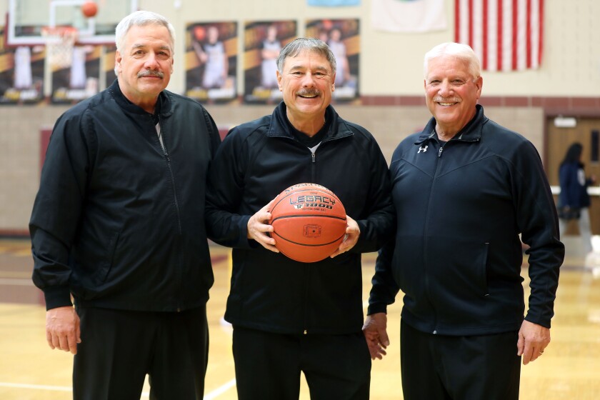 Three adult males posing while serving as basketball referees.