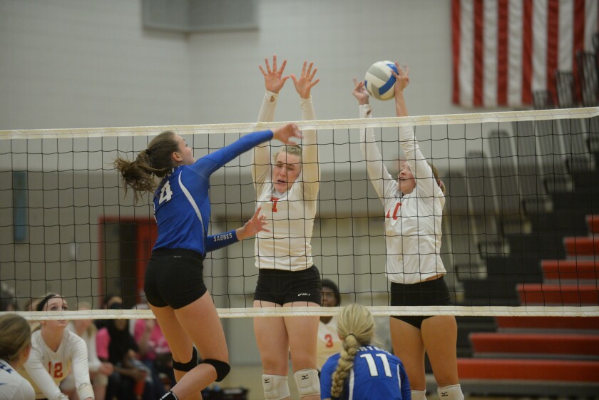 Willmar's Heidi Sellmann, center, and Caitlin Ogdahl attempt to block a shot from Sartell-St. Stephen's Jaden Turner in the first set of Tuesday night's 3-1 Cardinal win over the Sabres in Willmar. Jake Schultz / Tribune
