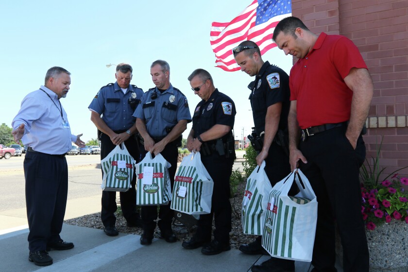 Sam Anderson (left), director of Brainerd’s Minnesota Adult and Teen Challenge program, prays with law enforcement officers Russ Wicklund, Jim Exsted, Mike Bestul, Paul Rosier and Craig Katzenberger Tuesday outside of Perkins in Brainerd. (Kelly Humphrey/Brainerd Dispatch)