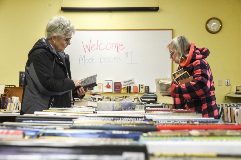 Erica Dischino / Tribune Jean Rood, left, and Cathy Wick take their time looking through the hundreds of books for sale at the Willmar Community Center for the annual League of Women Voters fundraiser. Books will be sold from 9 a.m. to 6:30 p.m. Friday and 9 a.m. to noon Saturday.