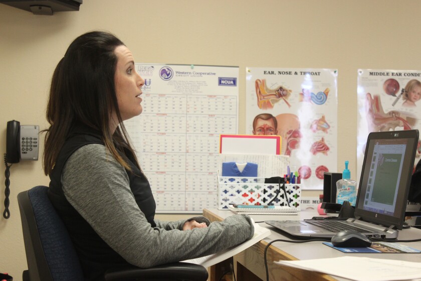 Bobbi Schneider sits at her desk in front of a camera as she discusses class work with students through ITV. Schneider teaches students in real-time without being in the same physical location as her students. (Press Photo by Kalsey Stults)