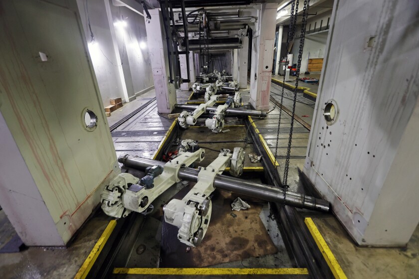 Large pipes with attached machinery rest on a concrete floor.