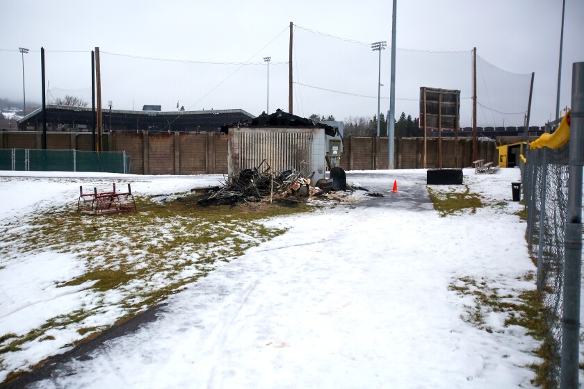Damage to a structure at baseball fields in the winter and debris surrounding it.