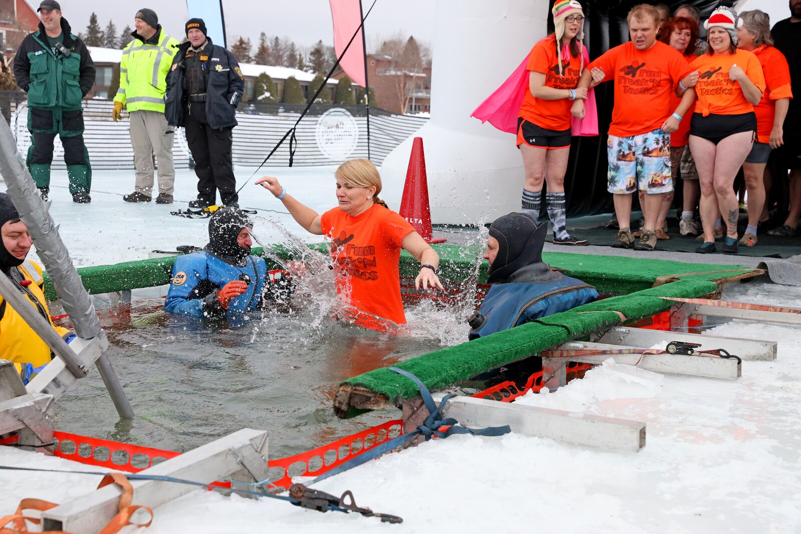People jump into the water during the Polar Plunge event on Pelican Lake.