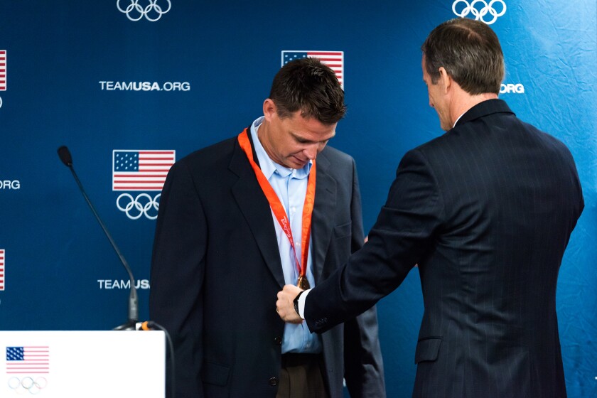 South Dakota Associate Director of Track and Field/Jumps Derek Miles receives his Olympic bronze medal in pole vaulting from Sen. John Thune on Monday, April 17, 2017, at the DakotaDome in Vermillion.