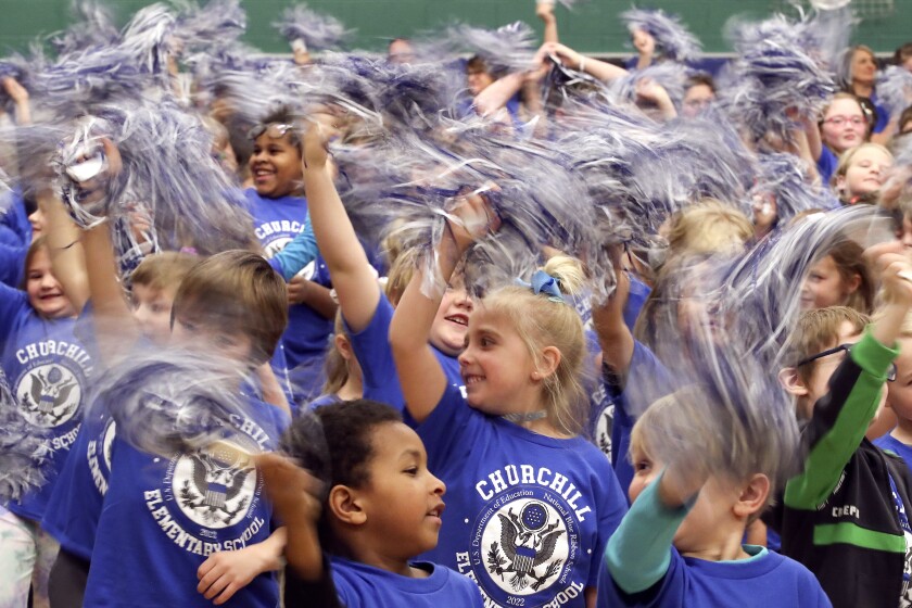 Students wave pom poms.