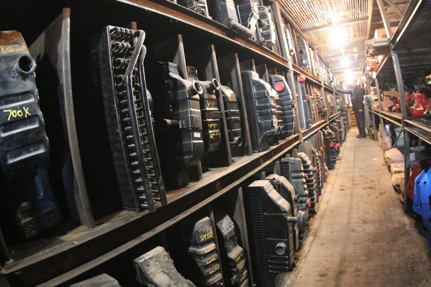 Radiators stand on shelves in a warehouse.