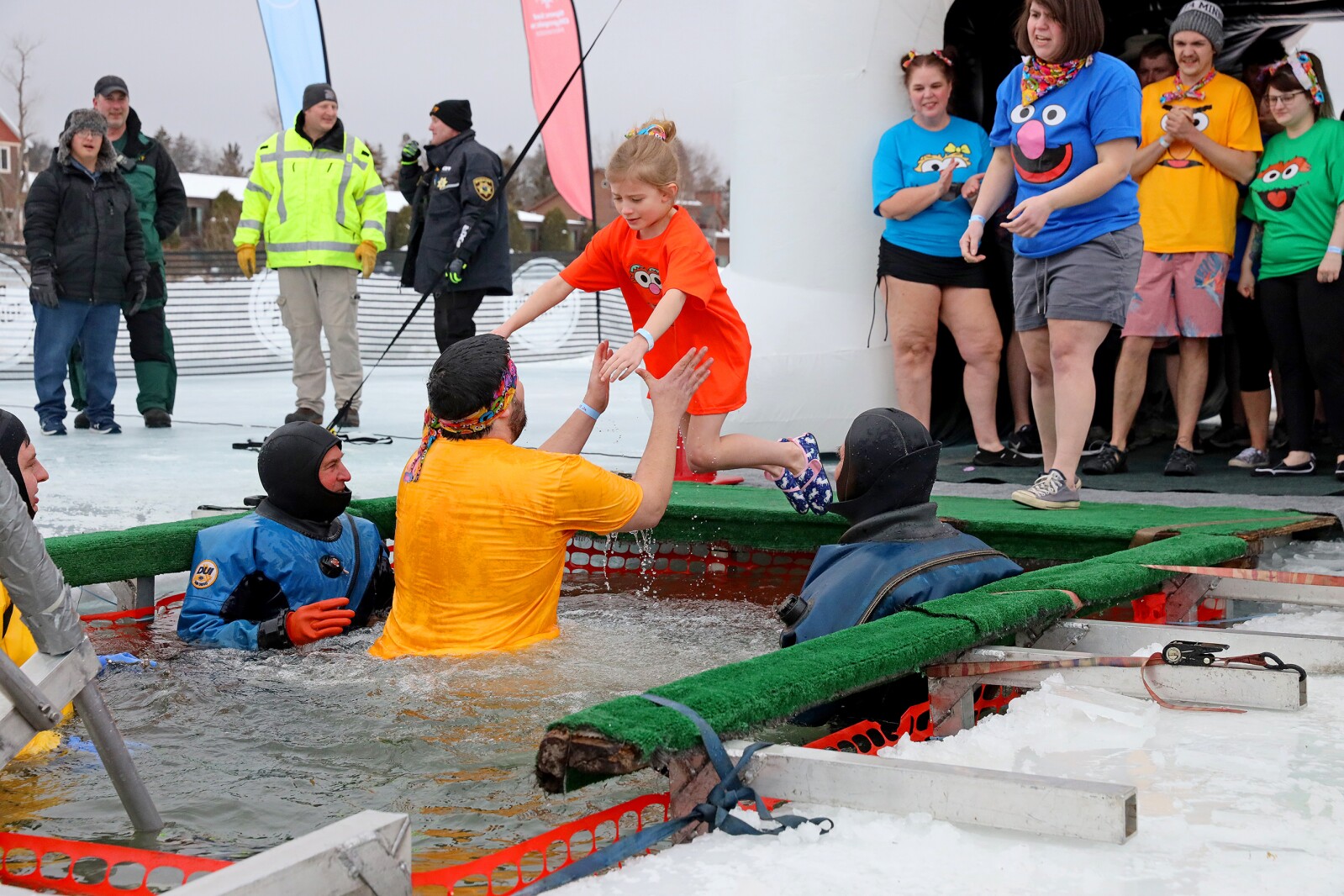 People jump into the water during the Polar Plunge event on Pelican Lake.