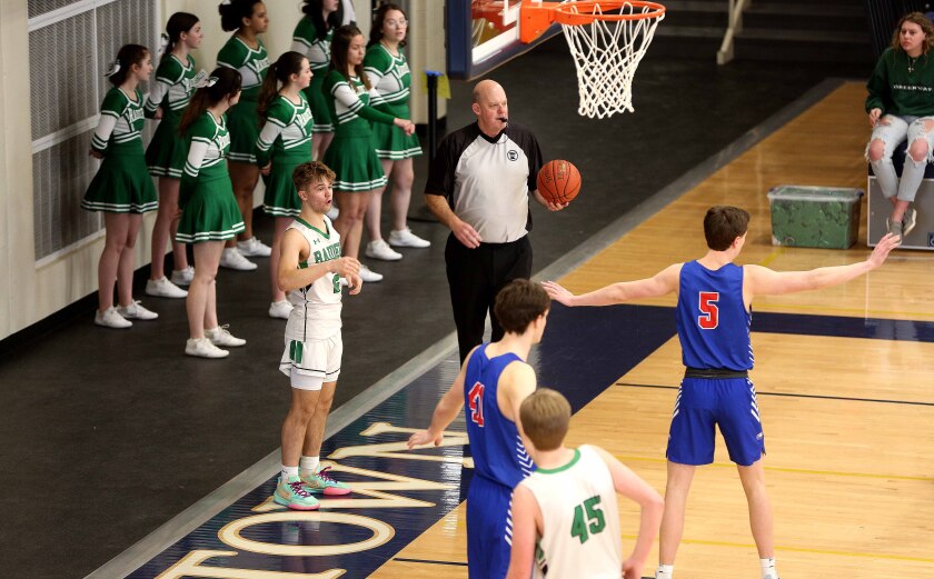 referee holds basketball before handing it to a player