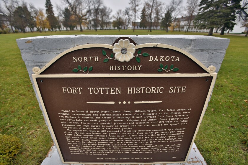 A stone marker offers paragraphs about the Fort Totten historic site.