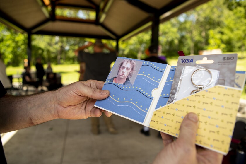 Gerald Cloutier Jr. looks at his intake mug shot from 2019 following his graduation from 8th Judicial District Drug Court at Robbins Island Regional Park on June 8, 2022.