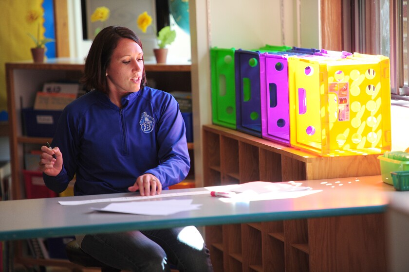 After an all-school meeting Monday, Lowell first-grade teacher Ashley Kunesh returns to her classroom to begin writing student names on a banner that will line the bulletin board. Steve Kohls/ Brainerd Dispatch