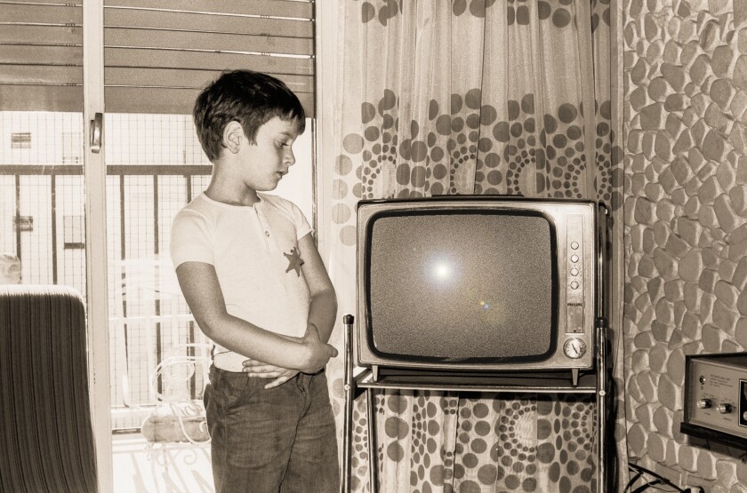 Vintage boy looking at an old tv
