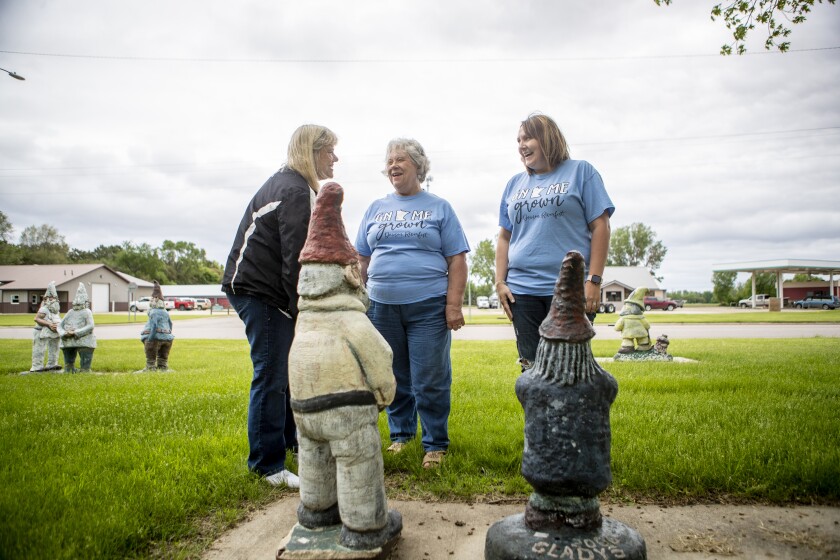 Diane Nevins, from left, Sharilyn Bates and Jesi Martinson laugh while chatting about the Dawson gnomes in the city park on Tuesday, May 31, 2022.