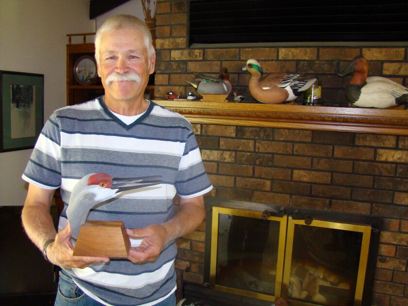 Joel Huener's carving creations include as this sandhill crane head, which sits among hand-carved working duck decoys on the mantel of the fireplace in his home near Middle River, Minn. (Photo/ Brad Dokken, Grand Forks Herald)