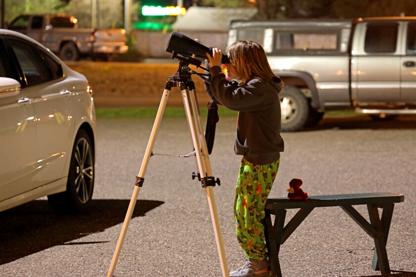 Sterling Kramer looks through binoculars during the lunar eclipse.