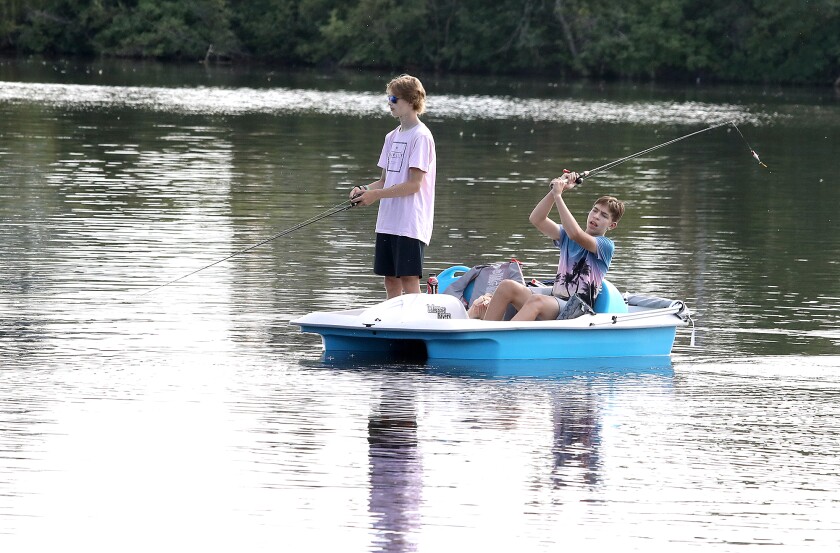 Dylan Johnson, left, watches his line as Ryland Doolittle casts from their paddle boat into the Superior Bay