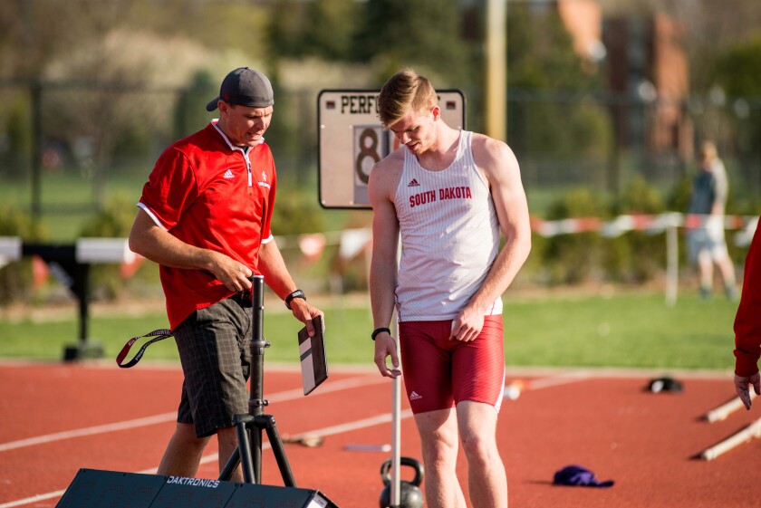 South Dakota's Chris Nilsen talks with coach Derek Miles at the USD Twilight track and field meet Monday, April 24, 2025, in Vermillion.
