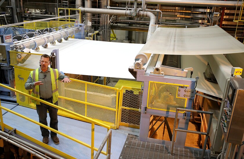 Man leads tour of pulp dryer.